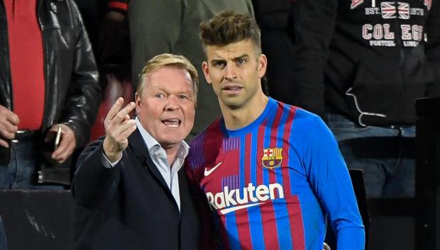 Barcelona's Dutch coach Ronald Koeman (L) gives instructions to Barcelona's Spanish defender Gerard Pique during the Spanish League football match between Rayo Vallecano de Madrid and FC Barcelona at the Vallecas stadium in Madrid on October 27, 2021. (Photo by OSCAR DEL POZO / AFP)
