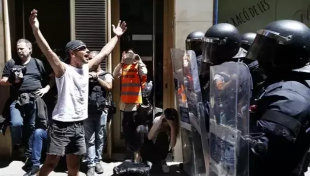 Un okupa enfrentándose a la Policía en Barcelona