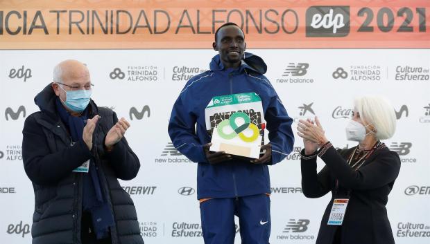 El keniano Lawrence Cherono, entre Juan Roig y Hortensia Herrero, recoge el premio tras ganar el maratón de Valencia Trinidad Alfonso DEP con un tiempo oficioso de 2:05:11