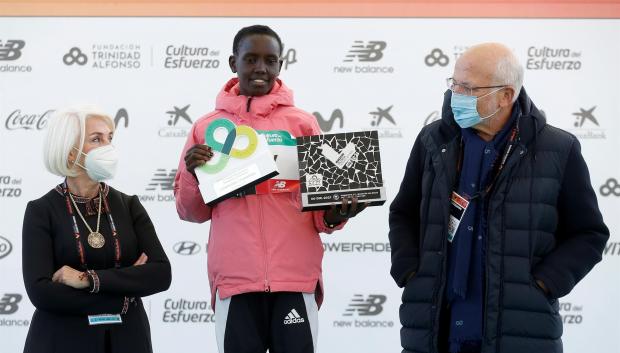La atleta keniana Nancy Jelagat entre Juan Roig y Hortensia Herrero, recoge el premio tras ganar el maratón de Valencia Trinidad Alfonso DEP con un tiempo de oficioso de 2:19:30