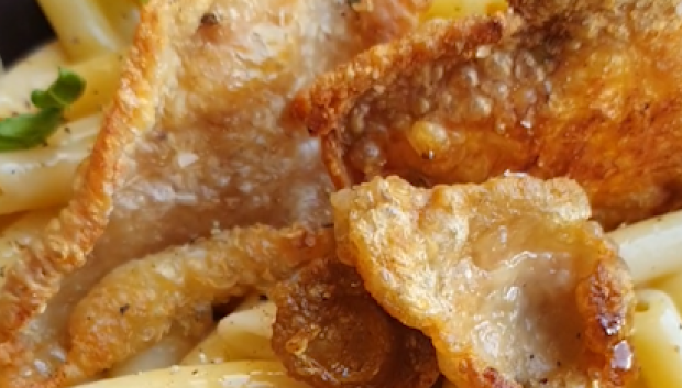 Pasta carbonara con yema curada en soja y pieles de pollo