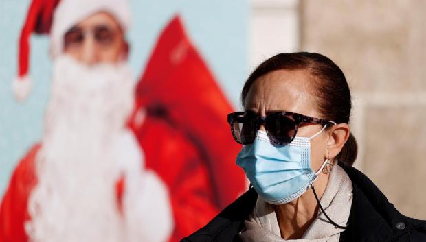 Una mujer porta una mascarilla quirúrgica en la calle, tras la vuelta a la obligatoriedad, esta Navidad