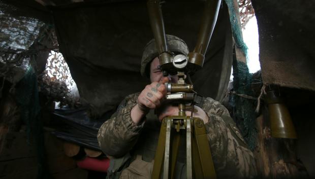Un militar ucraniano mira a través del catalejo su posición en la línea del frente con los separatistas respaldados por Rusia, cerca de Novolugansk