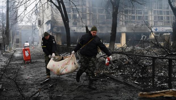 gentes de policía retiran el cuerpo de un transeúnte muerto durante un bombardeo en Kiev