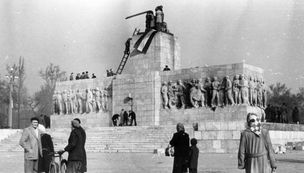 En Budapest, anticomunistas y nacionalistas colocan una bandera nacional húngara sobre una estatua demolida de Josef Stalin