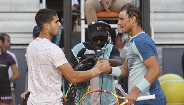 El tenista Carlos Alcaraz, y el tenista Rafael Nadal, se estrechan la mano tras el encuentro de cuartos de final del Mutua Madrid Open este viernes en la Caja Mágica en Madrid