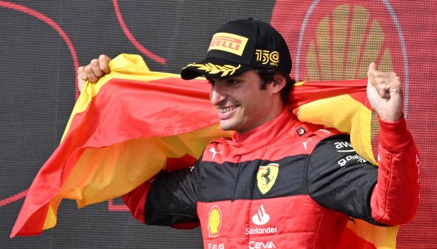 Carlos Sainz, engalanado con la bandera de España, celebra su victoria en Silverstone
