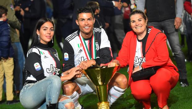 Juventus' Cristiano Ronaldo, center, is flanked by Georgina Rodriguez , left, and his mother Dolores Aveiro, right, after winning the Serie A soccer title trophy, at the Allianz Stadium, in Turin, Italy, Sunday, May 19, 2019.  *** Local Caption *** .