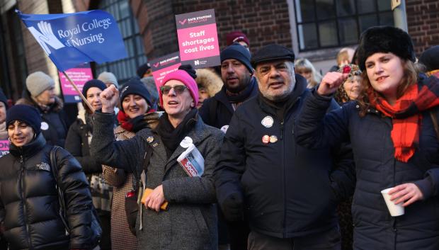 Supporters of nurses' strike and NHS shout slogans at a picket line outside St Mary's Hospital in west London on December 15, 2022. - UK nurses staged an unprecedented one-day strike as a "last resort" in their fight for better wages and working conditions, despite warnings it could put patients at risk. (Photo by ISABEL INFANTES / AFP)