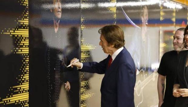 El músico Raphael firmando un autógrafo en el pasillo de la música, en la estación de Estadio Metropolitano