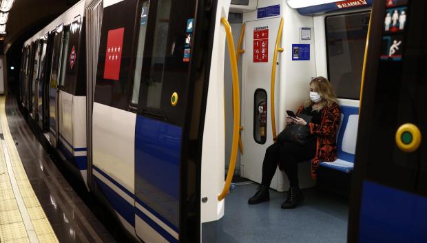Una mujer usa el móvil en el metro de Madrid durante la pandemia
