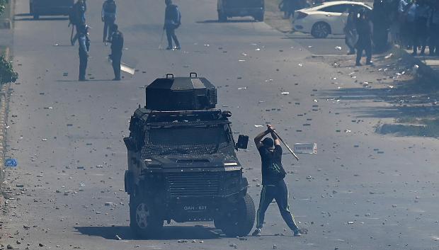 Un partidario del ex primer ministro de Pakistán, Imran Khan, golpea un vehículo blindado de la policía durante una protesta