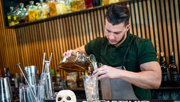 Un camarero prepara pisco