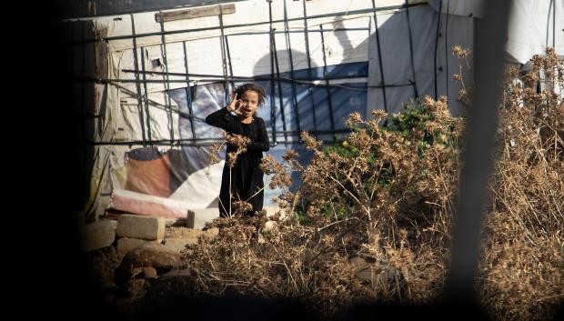 Una niña de un campo de refugiados sirio pidiendo agua