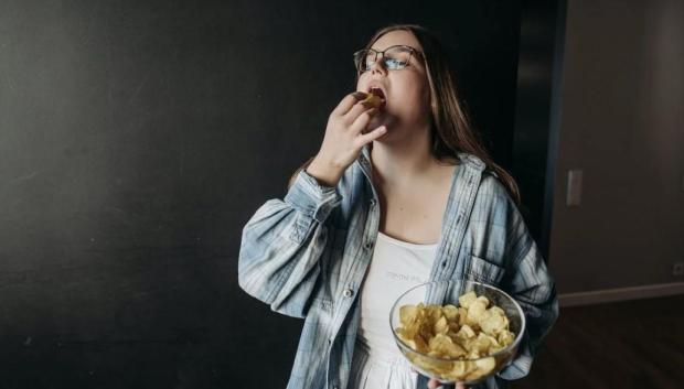 Una chica come patatas fritas, en una imagen de archivo