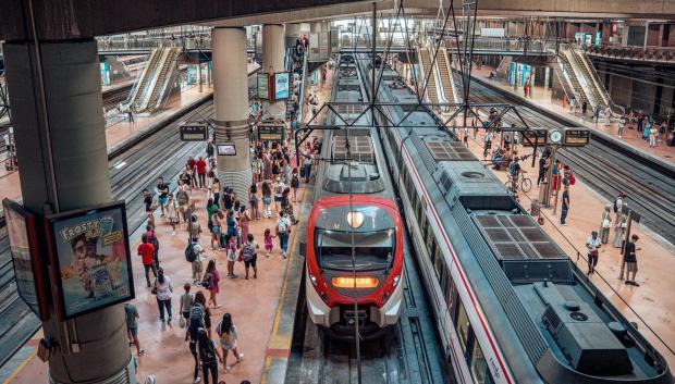 Varias personas en el andén de un tren de cercanías en la estación Almudena Grandes-Atocha