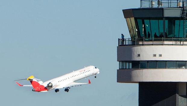 Torre de control del Aeropuerto de Castellón, con un avión de fondo