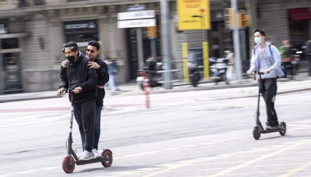 Dos personas en un sólo patinete y sin casco