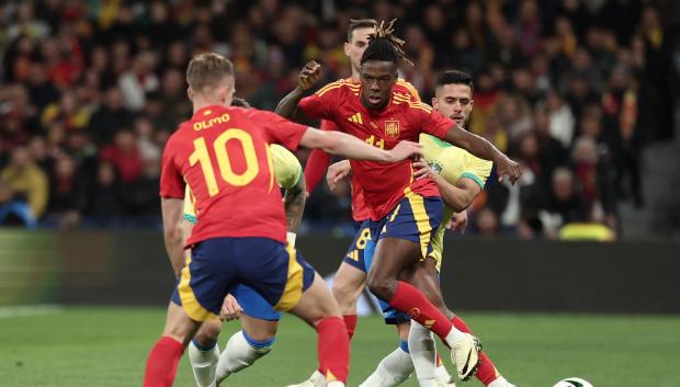 Nico Williams pelea un balón con la defensa brasileña