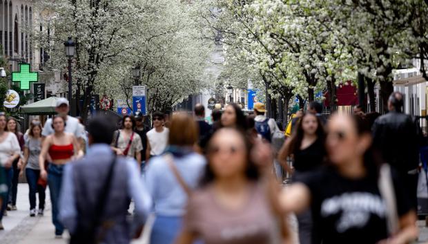 Varias personas pasean junto a árboles en flor durante el primer día de primavera en Madrid