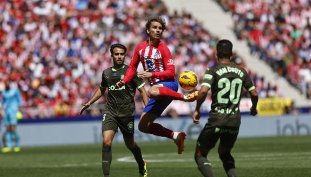 Antoine Griezmann intenta controlar un balón ante los jugadores del Girona