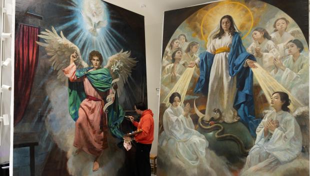 Raúl Berzosa junto a sus pinturas de la Catedral de Pekín