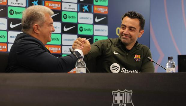 Joan Laporta y Xavi se abrazan durante la rueda de prensa