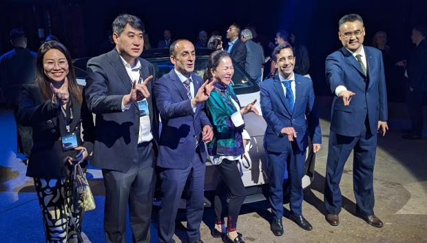Representantes de la empresa china posan durante la ceremonia en la que se presentaron los coches chinos