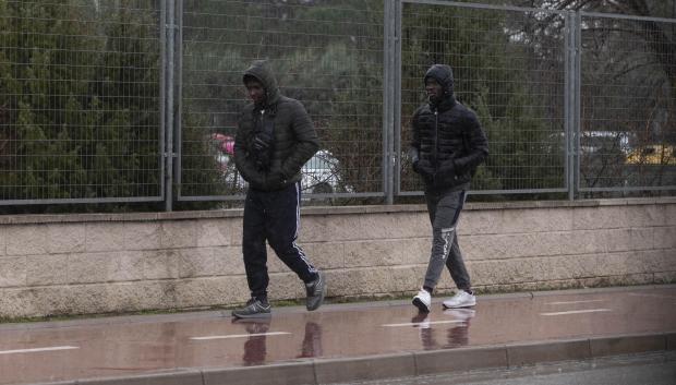 Dos inmigrantes caminan en las inmediaciones del centro de Emergencia, Acogida y Derivación en el Acuartelamiento 'Primo de Rivera'