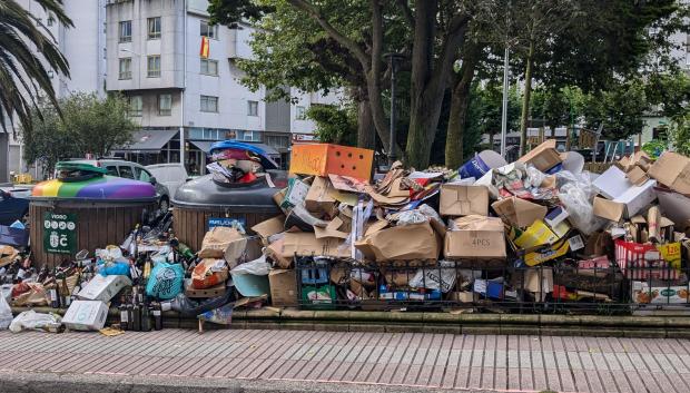 Cartón y vidrio acumulados junto a unos contenedores junto a un parque de La Coruña