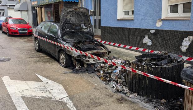 Un coche que quedó inservible tras un fuego en unos contenedores de La Coruña