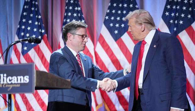 Mike Johnson, líder de la mayoría republicana en la Cámara de Representantes saluda a Donald Trump