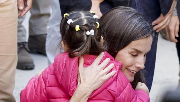 La Reina Letizia abraza a una niña durante la visita a Chiva