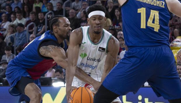 El jugador del Unicaja Málaga, Kameron Taylor (c) con el balón ante los jugadores del FC Barcelona, Kevin Punter (i) y "Willy" Hernangómez (d)