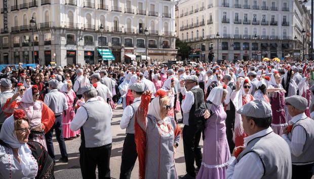 Cientos de personas bailan el chotis durante el pasacalles castizo