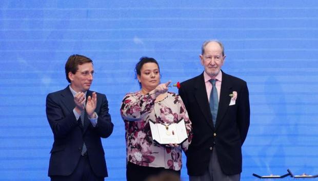 El alcalde de Madrid, José Luis Martínez-Almeida, entrega la distinción a la representante de la Cuesta de Moyano