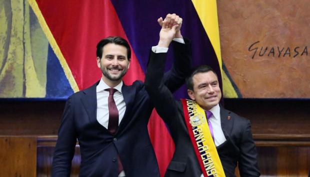 El presidente de la Asamblea Nacional, Niels Olsen (izq.), levantando la mano del presidente reelegido, Daniel Noboa tras colocarle la banda presidencial