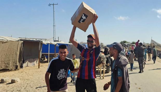 Palestinos desplazados reciben paquetes de alimentos de una fundación respaldada por Estados Unidos que se compromete a distribuir ayuda humanitaria en el oeste de Rafah, en el sur de la Franja de Gaza