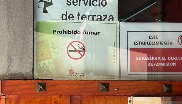 Cartel de prohibido fumar en la puerta de un bar