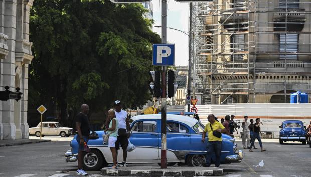 Personas junto a un semáforo apagado durante un apagón en La Habana