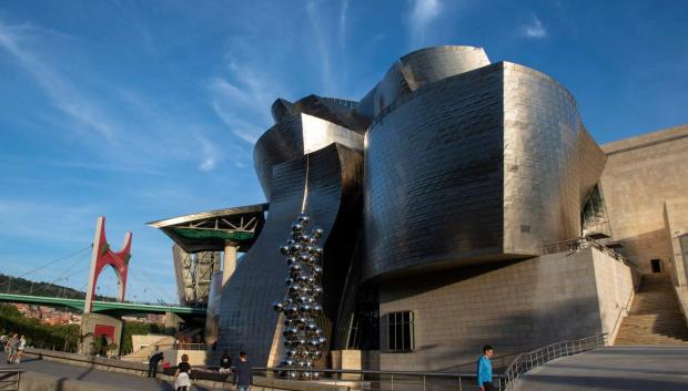 Frank Gehry construyó en piedra caliza, vidrio y titanio este conjunto de formas heterogéneas a orillas del Nervión. El Museo Guggenheim de Bilbao requirió para su diseño un software de la industria aeroespacial y la intervención de alpinistas para instalar las cerca de 33.000 láminas de titanio ultraligero de la fachada.