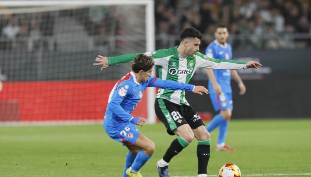 Giuliano Simeone (i) presiona al centrocampista del Real Betis Marc Roca durante el partido de cuartos de final de la Copa del Rey que Real Betis y Atlético de Madrid
