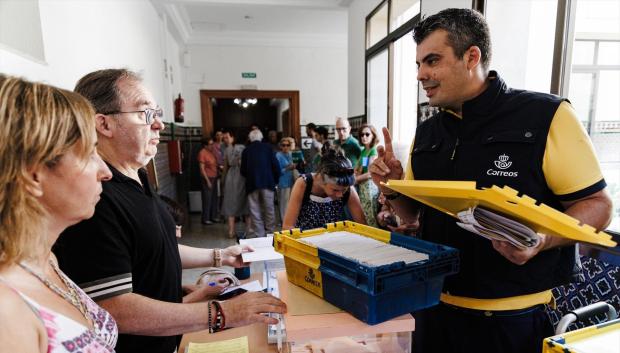 Trabajador de Correos entrega el voto por correo durante las elecciones generales de 2023 en una mesa electoral de Madrid
