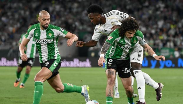 Real Madrid's Brazilian forward #07 Vinicius Junior (C) vies for the ball with Real Betis' Spanish defender #02 Hector Bellerin (R) and Real Betis' Moroccan midfielder #14 Sofyan Amrabat during the Spanish league football match between Real Betis and Real Madrid CF at the La Cartuja stadium in Seville on April 24 , 2026. (Photo by CRISTINA QUICLER / AFP)