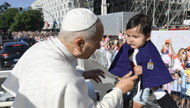 León XIV acoge a un niño antes de llegar a la misa de ayer domingo en Cibeles