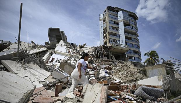Una mujer busca entre los escombros de un edificio derrumbado mientras intenta recuperar sus pertenencias tras un terremoto en Catia La Mar, estado de La Guaira.