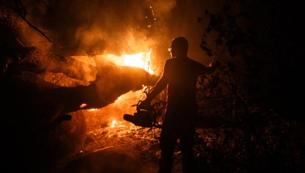 Una persona trabaja en las labores de extinción del incendio forestal en La Adrada, Ávila, Castilla y León (España).
