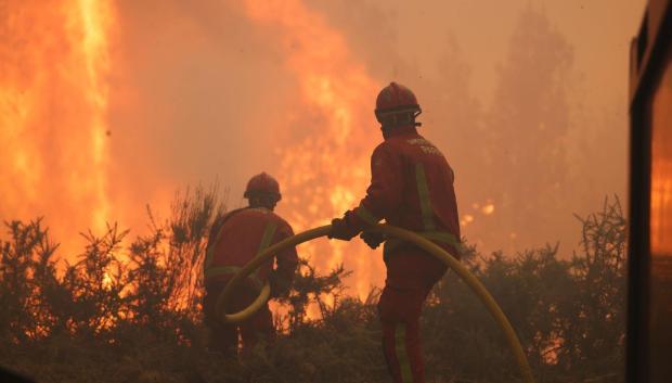 Unos bomberos combaten el fuego de estos días