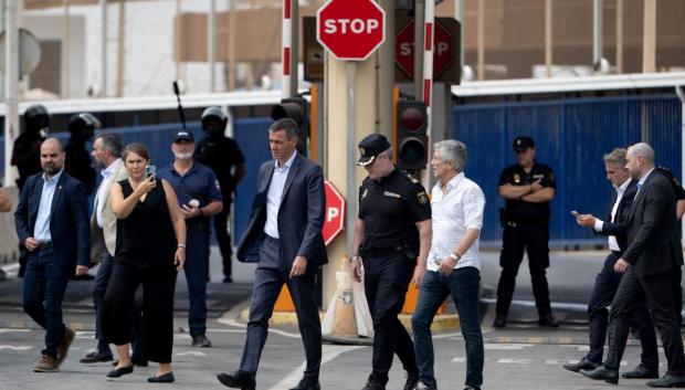 Pedro Sánchez (centro) y el ministro del Interior, Fernando Grande-Marlaska, caminan junto a la valla fronteriza de El Tarajal durante una visita para gestionar una de las mayores crisis migratorias en la frontera del país