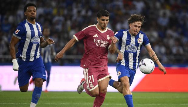 Deportivo La Coruna's Spanish midfielder #21 Mario Soriano Carreno (R) and Real Madrid's Moroccan forward #21 Brahim Diaz (C) vie for the ball during the Teresa Herrera Trophy friendly football match between RC Deportivo de la Coruna and Real Madrid CF at Municipal de Riazor Stadium in A Coruna on August 12, 2026. (Photo by Miguel RIOPA / AFP)